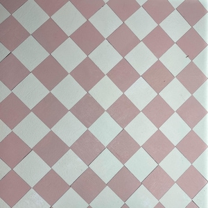 May include: A close-up shot of a tiled surface with a repeating pattern of pink and white diamond shapes. The diamonds are arranged in a checkerboard design, creating a visually appealing and symmetrical pattern. The tiles have a slightly textured appearance.