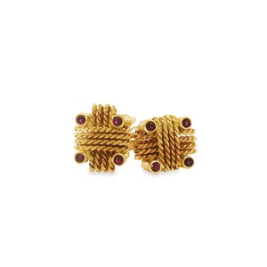 May include: A pair of gold-toned cufflinks featuring a square, rope-textured design. Each cufflink is accented with four small, round, deep red stones set at the corners of the square structure, creating a symmetrical and detailed appearance.