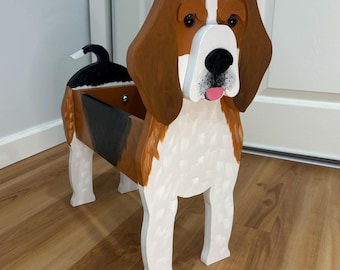 May include: A wooden planter shaped like a beagle dog with brown, white, and black painted details. The dog figure features long brown ears, a white muzzle, a black nose, and a pink tongue. The hollow body serves as a container for plants.