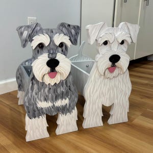 May include: Two wooden dog-shaped storage containers. One is painted in shades of gray and white with a textured coat, while the other is solid white. Both feature carved details, black noses, and pink tongues, with open compartments at the back.