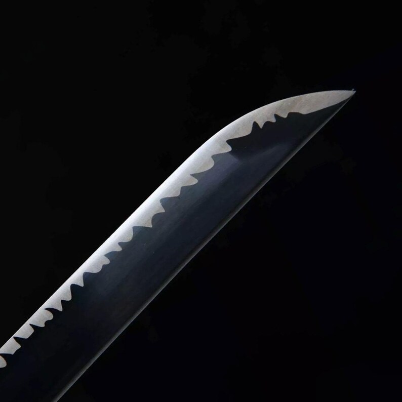 May include: Close-up of a katana blade with a distinctive wavy edge. The blade is dark with a polished, reflective surface. The edge is a lighter color, creating a contrast against the dark background.