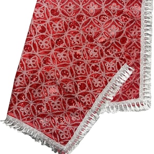 May include: Red velvet fabric with a silver embroidered pattern and a silver fringe border. The fabric has a shiny, sequined texture.