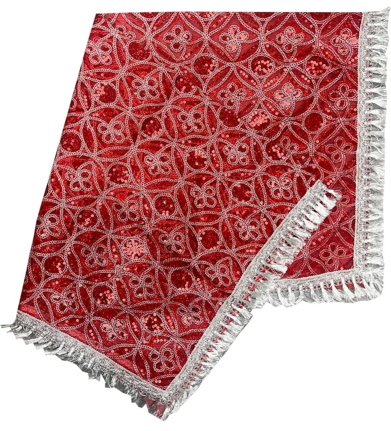 May include: Red velvet fabric with a silver embroidered pattern and a silver fringe border. The fabric has a shiny, sequined texture.