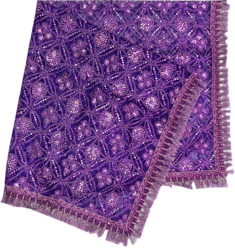 May include: Purple sequined table runner with a fringe border. The runner has a geometric pattern and is made of a soft, luxurious fabric.