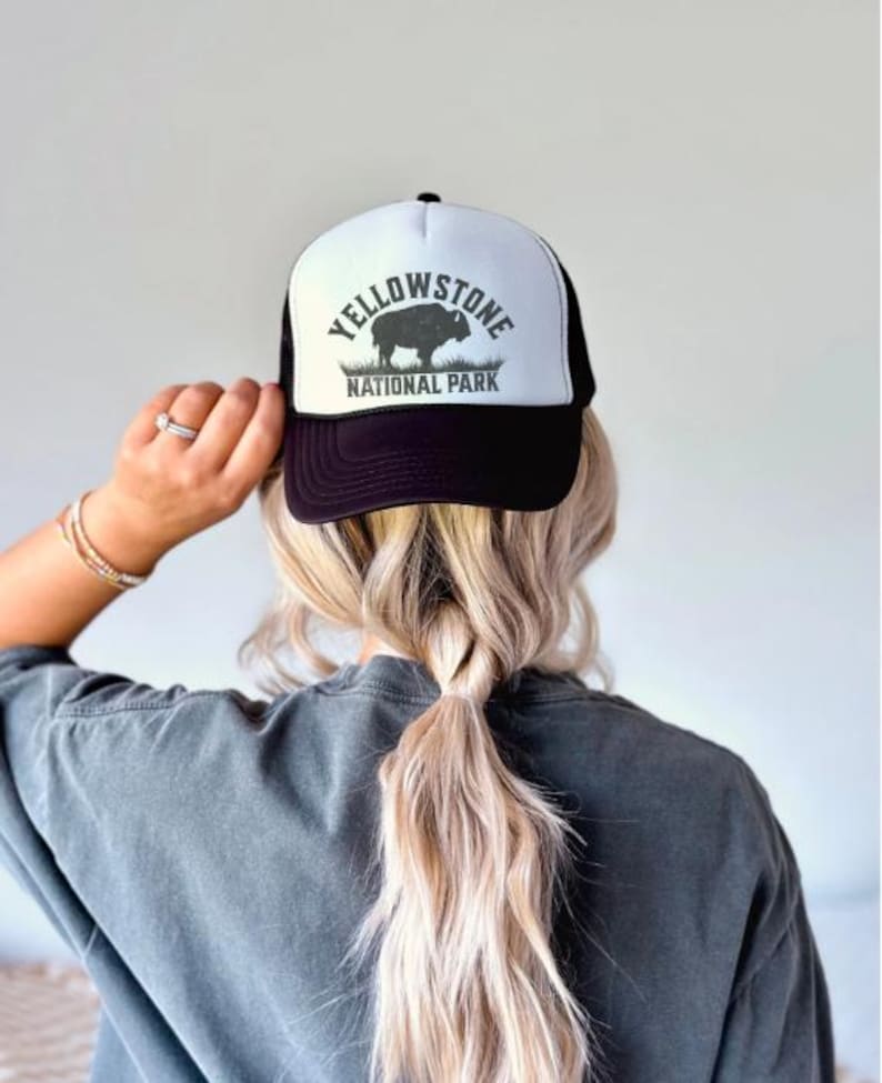 May include: Black and white trucker hat with a white logo that says "Yellowstone National Park" and a silhouette of a bison.