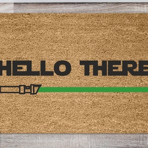 May include: A brown doormat with the text "HELLO THERE" in black letters and a green lightsaber graphic.