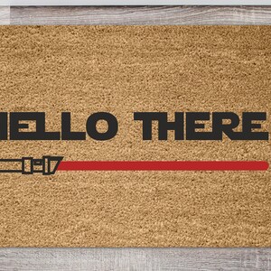 May include: A brown doormat with the text "HELLO THERE" in black letters and a red lightsaber graphic.