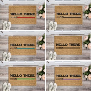 May include: Five doormats with the text "HELLO THERE" and a lightsaber graphic. The doormats are brown and each has a different colored lightsaber: red, black, teal, green, and purple.