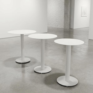 May include: Three white circular tables, each featuring a smooth, flat tabletop supported by a single central cylindrical column and a round, stable base. The tables are arranged in a staggered formation, showcasing a uniform matte white finish.