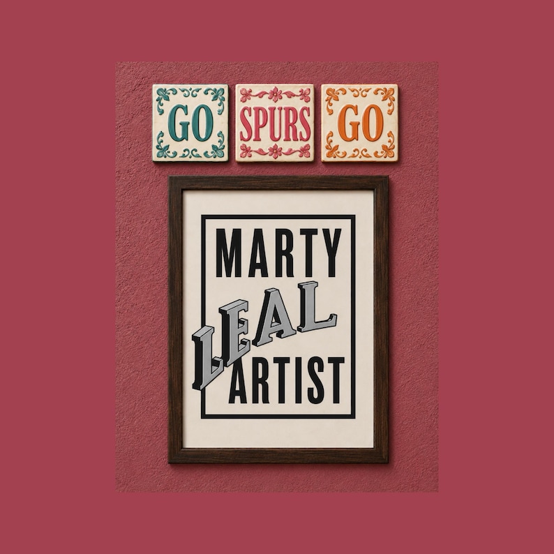 May include: A rectangular framed print with a black border containing the text MARTY LEAL ARTIST in black and grey block letters. Above the frame are three square tiles with floral borders, displaying the text GO, SPURS, and GO in teal, red, and orange.