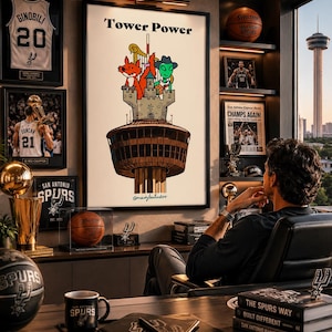 May include: A framed poster titled Tower Power featuring a cartoon illustration of a fox and an alien standing on a stone castle atop a brown tower. The artwork includes a harp and a basketball, set against a white background with a signature.