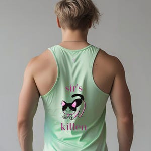 Può includere: Canotta verde chiaro con le parole "sir's kitten" e una grafica di gattino dei cartoni animati in rosa e nero. La canotta è senza maniche e ha un design a vogatore.