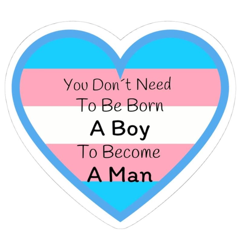 May include: A heart-shaped sticker with a blue outline and the transgender pride flag colours inside. The text reads, "You Don't Need To Be Born A Boy To Become A Man."