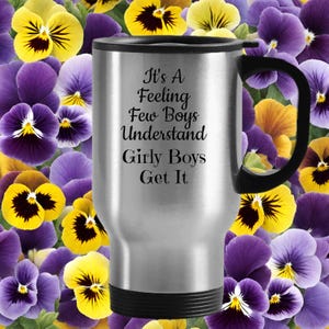 Può includere: Una tazza da viaggio argentata con manico e base neri. La tazza presenta il testo nero "It's A Feeling Few Boys Understand Girly Boys Get It". Lo sfondo è una composizione floreale di viole gialle e viola.