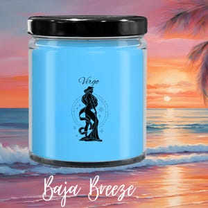 May include: A light blue candle in a glass jar with a black lid. The candle has a black graphic of a woman with long hair and the word "Virgo" above it. The words "Baja Breeze" are written in cursive at the bottom.