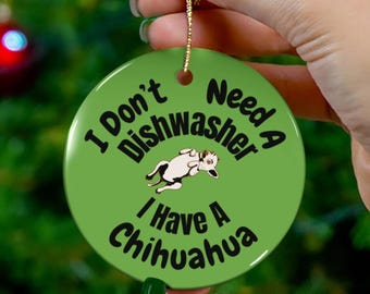 May include: A round, green ceramic ornament with the text "I Don't Need A Dishwasher I Have A Chihuahua." The ornament features a black and white cartoon chihuahua. A gold string is attached for hanging.