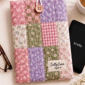 May include: A rectangular quilted fabric sleeve for an e-reader featuring a patchwork design of pink, green, and purple floral and gingham patterns. It includes a light brown button closure with a white elastic loop and a label reading Sally Luna style.