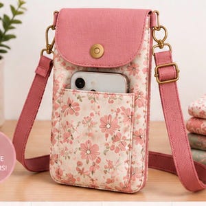 Könnte beinhalten: Eine vertikale Umhängetasche für Smartphones mit rosa Blumenmuster auf cremefarbenem Grund, einer einfarbig rosa Klappe und einem goldenen Druckknopfverschluss. Die Tasche hat einen verstellbaren rosa Riemen und ein Vorderfach mit Smartphone. Text: QUICK & EASY FOR TRUE BEGINNERS!