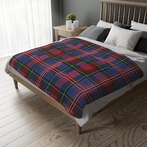 Può includere: Coperta in plaid rosso, blu e giallo su un letto con testiera in legno.