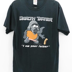 May include: Black t-shirt featuring a cartoon Darth Vader-inspired potato character with the text "Darth Tater" above and "I am your father" below. The character holds a lightsaber and a french fry.
