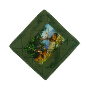 May include: A square, quilted, forest green pot holder. The center features a rectangular image of deer in a forest landscape. The pot holder has a diamond pattern and a dark green border.