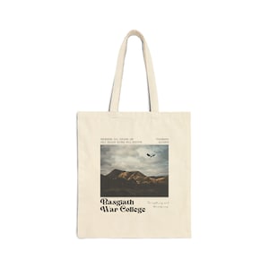 May include: Cream-colored tote bag featuring a graphic of a mountain landscape with a flying bird. The text "Basgath War College" is printed below the image. Additional text includes "The night may end, the only way."