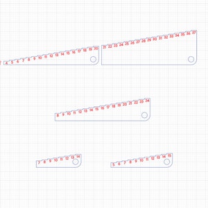Pu&ograve; includere: Quattro righelli di diverse dimensioni con segni graduati. I righelli sono in plastica bianca e hanno un contorno blu. I numeri sui righelli sono rossi.