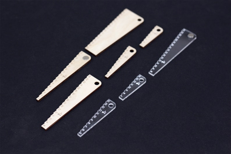Pu&ograve; includere: Set di sei righelli in legno e plastica trasparente con diverse lunghezze e marcature. I righelli hanno un foro all'estremit&agrave; per essere appesi.