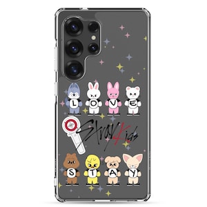 Puede incluir: Funda transparente para teléfono con un diseño de personajes de animales de dibujos animados y el texto "LOVE STAY". La funda también incluye las palabras "Stray Kids" en una fuente estilizada. El fondo tiene un patrón de estrellas de varios colores.
