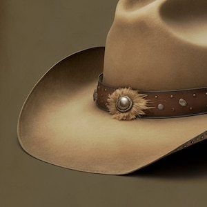 Könnte beinhalten: Ein brauner Cowboyhut mit einem braunen Lederband und einem silbernen Concho mit Federschmuck.