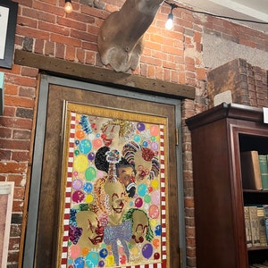 May include: A colorful beaded tapestry depicting multiple clowns with a red, white, and gold border. The tapestry is hanging on a wooden door with a price tag that reads "Beadwork Tapestry $450". A mounted deer head is above the door.