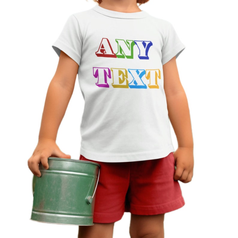 a little girl wearing a white shirt and red shorts holding a green bucket