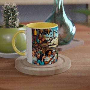 Pode incluir: Uma caneca de cerâmica branca com uma borda amarela apresenta uma ilustração colorida de uma cena de mercado movimentada. A ilustração representa pessoas, edifícios e lanternas coloridas.