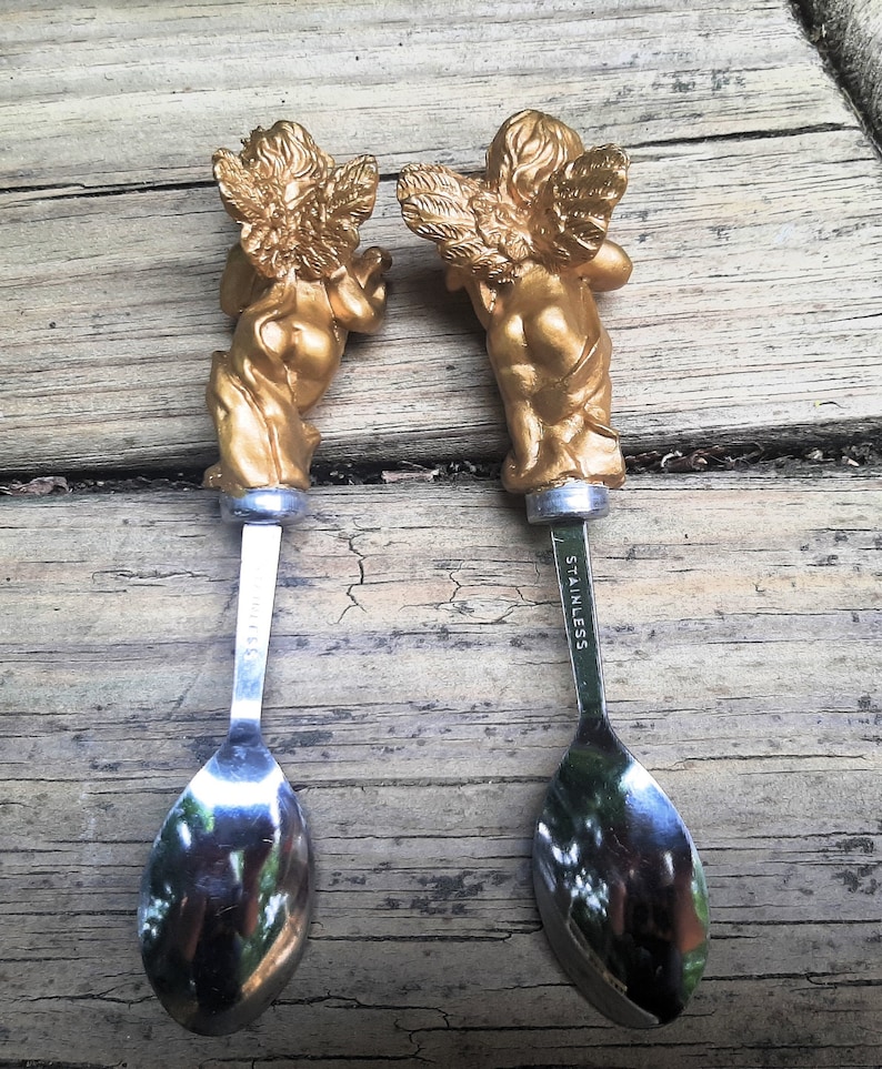 Two Stainless Steel Small Serving Spoons W Golden Cherubs Playing