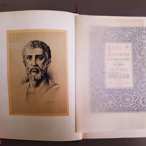 May include: A vintage book with a black and white illustration of a man with a beard on the front cover. The book's title is "Little Journeys" and is written in red and black text.