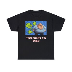 Könnte beinhalten: Schwarzes T-Shirt mit einer Cartoon-Illustration eines Mannes mit einer grünen Wolke hinter ihm. Der Text "Think Before You Stink!" ist unter dem Bild gedruckt.