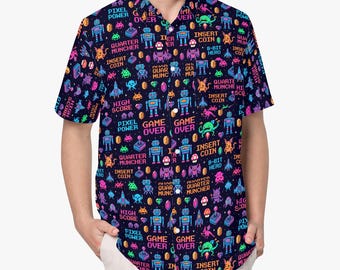 Pode incluir: Uma camisa de manga curta com botões em azul-marinho escuro com um padrão vibrante e repetitivo de videojogos de 8 bits. A estampa inclui robôs, monstros, gemas, joysticks e texto colorido como "GAME OVER", "INSERT COIN" e "HIGH SCORE".