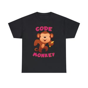 Puede incluir: Camiseta negra con un mono de dibujos animados sosteniendo un plátano y el texto "CODE MONKEY" en rosa.