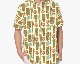 Pode incluir: Uma camisa de manga curta com botões na cor creme, apresentando uma estampa corrida de máscaras tiki castanhas, flores de hibisco laranja, folhas de palmeira verdes e tochas tiki acesas. A camisa inclui um colarinho padrão e um bolso.