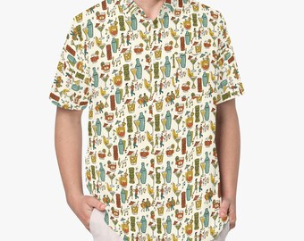 Pode incluir: Uma camisa de manga curta com botões em creme, apresentando um padrão repetitivo de canecas tiki, copos de cocktail, misturadores e pequenas figuras a dançar. A estampa utiliza uma paleta de cores azul-petróleo, amarelo-mostarda e laranja.
