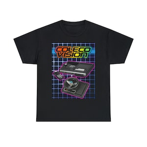 May include: Black t-shirt with a retro-style design featuring a ColecoVision console, a joystick, and a controller. The design is set against a blue and purple grid with the text "ColecoVision" in rainbow colors.