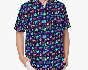 Pode incluir: Uma camisa de manga curta com botões em azul escuro apresentando um padrão pixelizado repetitivo de elementos de videogame, incluindo naves espaciais, cogumelos, corações, joysticks e os textos "GAME OVER" e "LEVEL UP" em cores neon.