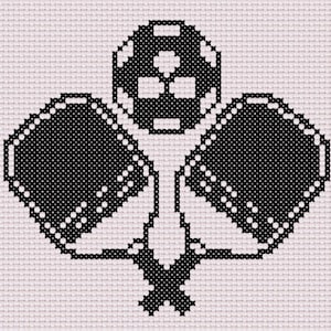 May include: Black and white cross-stitch design featuring a soccer ball and two pickleball paddles. The paddles have white dot detailing. The design is on a light pink background, creating a simple, yet striking image.