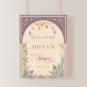 Könnte beinhalten: Ein Willkommenszeichen für eine Sangeet-Feier mit floralem Design und einem Torbogen. Das Schild lautet "Willkommen zu Divya's Sangeet, 21. März 2024".