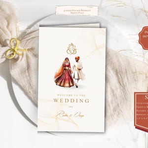 May include: A wedding invitation booklet with a watercolor illustration of a bride and groom in traditional Indian attire. The booklet is folded in fourths and has a white background with gold accents. The text on the front page reads "Welcome to the Wedding of [Bride's Name] & [Groom's Name]".