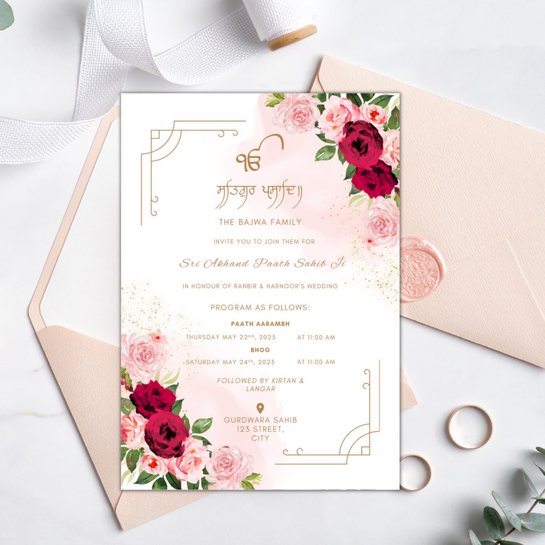 May include: A pink and white floral wedding invitation with gold accents. The invitation features a floral design with pink and red roses. The text on the invitation reads "Satiguru Prasadi" and "The Bajwa Family Invite You To Join Them For Sri Akhand Paath Sahib Ji In Honour Of Ranbir & Harnoor's Wedding". The invitation also includes the date and time of the wedding ceremony.