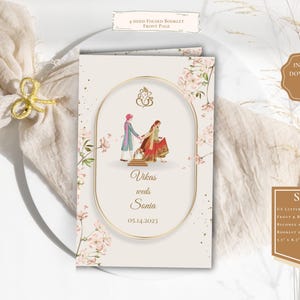 May include: A folded booklet front page with a gold oval frame featuring a couple in traditional attire. The text "Vikas weds Sonia 05.14.2023" is displayed. The booklet is decorated with floral accents and a gold bow.