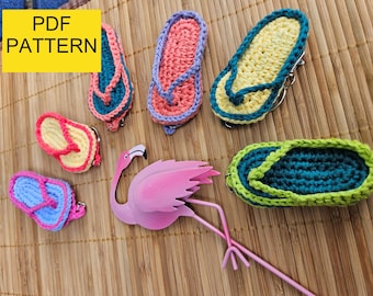 Op de afbeelding: Een verzameling kleurrijke, handgemaakte gehaakte slippers en een roze flamingo beeldje. De slippers zijn in verschillende kleuren, waaronder roze, blauw, geel en groen. De tekst "PDF PATTERN" staat in een gele doos.