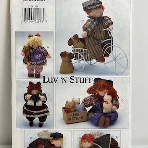 May include: A vintage sewing pattern for making six different dolls. The pattern is called "Luv 'N Stuff" and is from Butterick. The dolls include a boy on a bicycle, a girl with a teddy bear, a girl with a gift, a girl with kittens, and two angels.