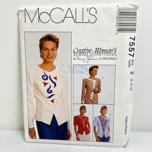 May include: A McCall's sewing pattern envelope featuring a woman's fashion design. The envelope includes a photo of a woman wearing a white top with red and blue abstract designs. The text on the envelope reads "Creative Woman's Sewing Patterns".